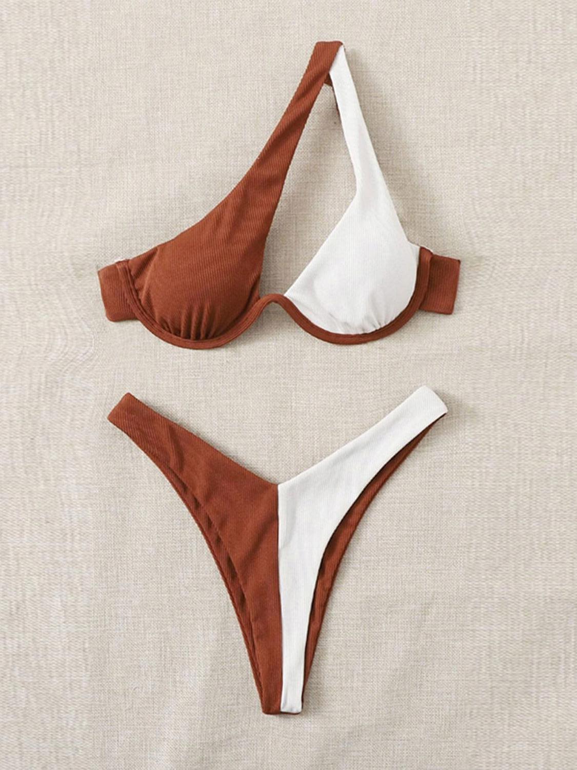a pair of brown and white bikinis laying on top of a bed