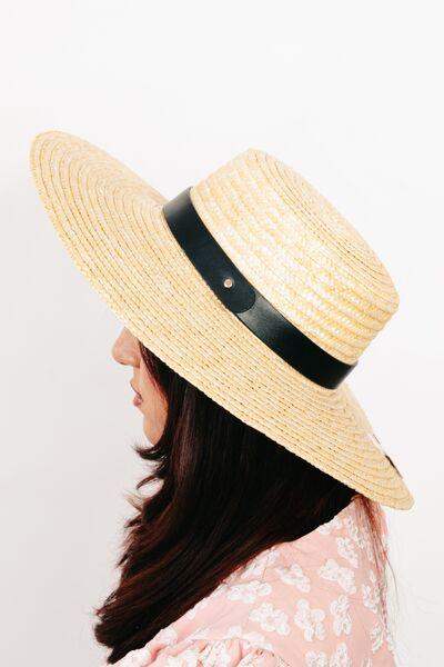 a woman wearing a straw hat with a black band