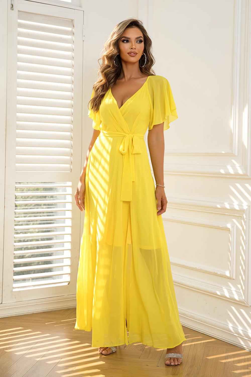 a woman in a yellow dress posing for a picture