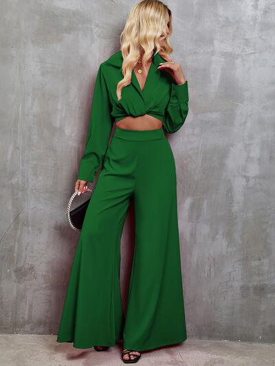 a woman in a green outfit leaning against a wall