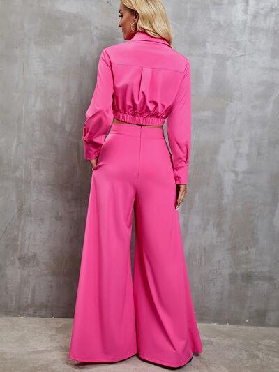 a woman in a pink jumpsuit standing against a wall
