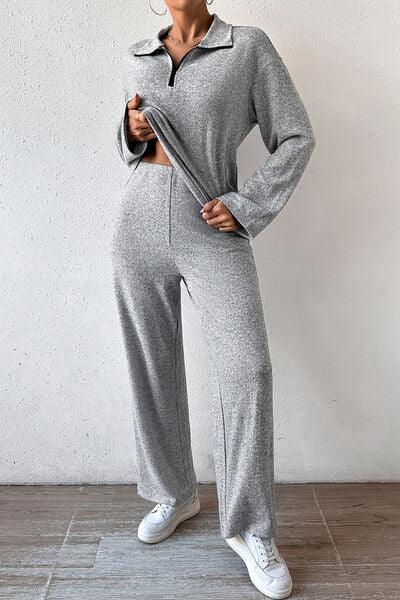 a woman wearing a grey jumpsuit and white sneakers