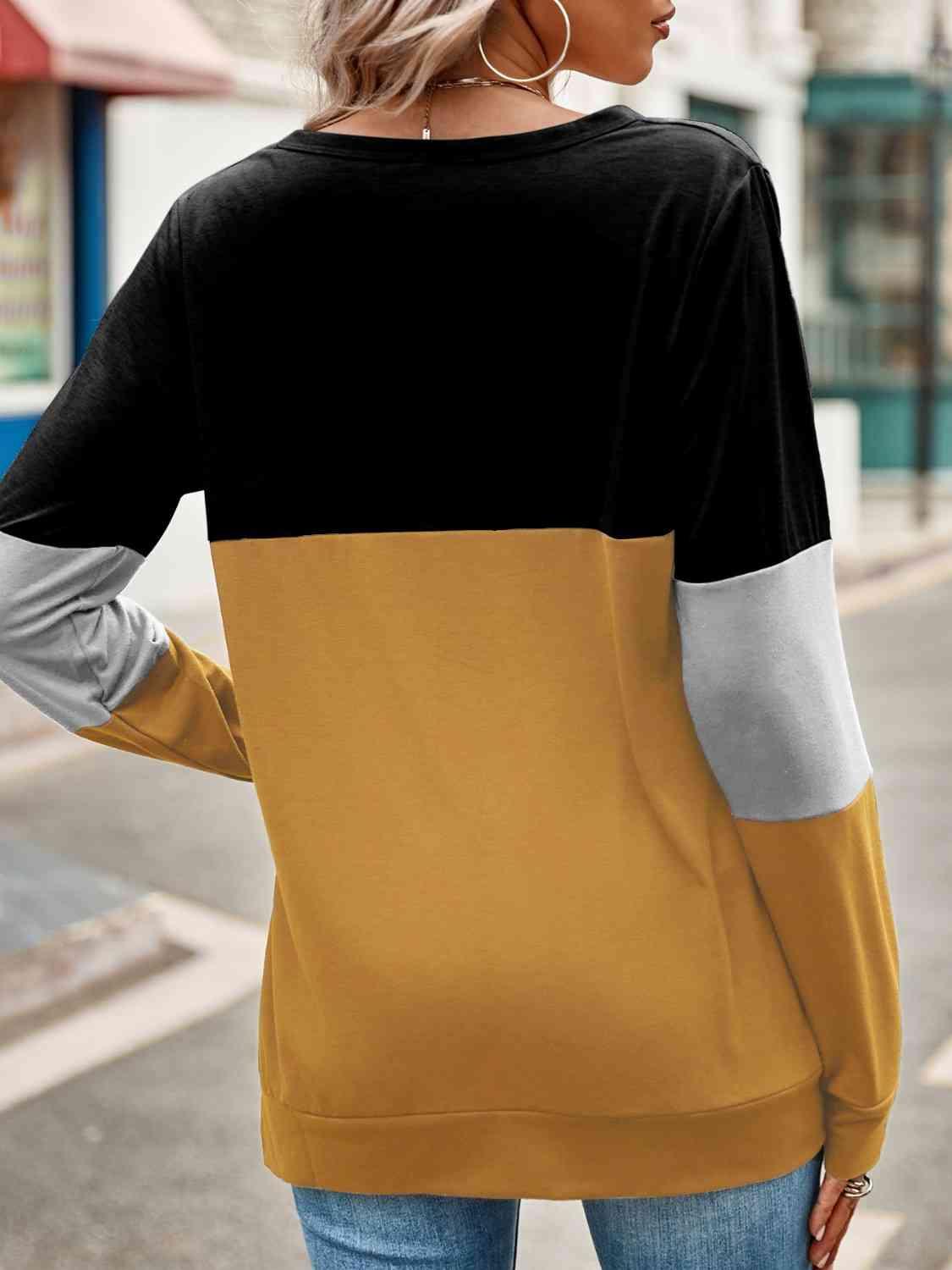 a woman wearing a black, yellow and grey top