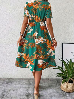 a woman wearing a green floral print dress