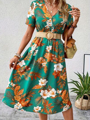 a woman wearing a green floral print dress