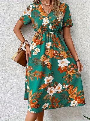 a woman wearing a green floral print dress