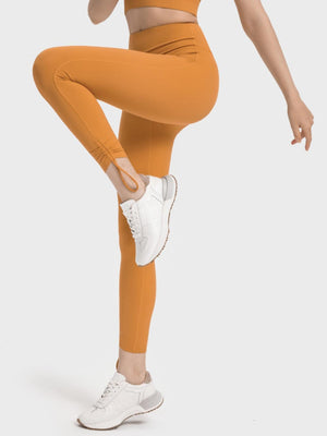 a woman in a sports bra top and orange leggings