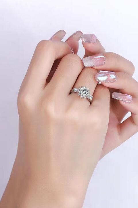 a woman's hand holding a diamond ring