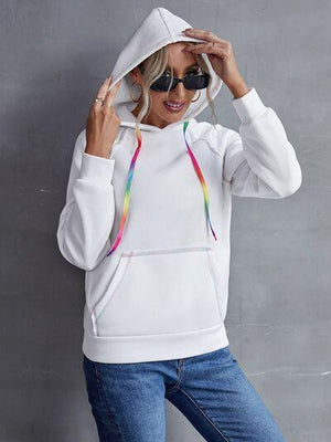 a woman wearing a white hoodie with a rainbow print on it