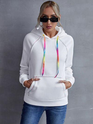 a woman wearing a white hoodie and sunglasses