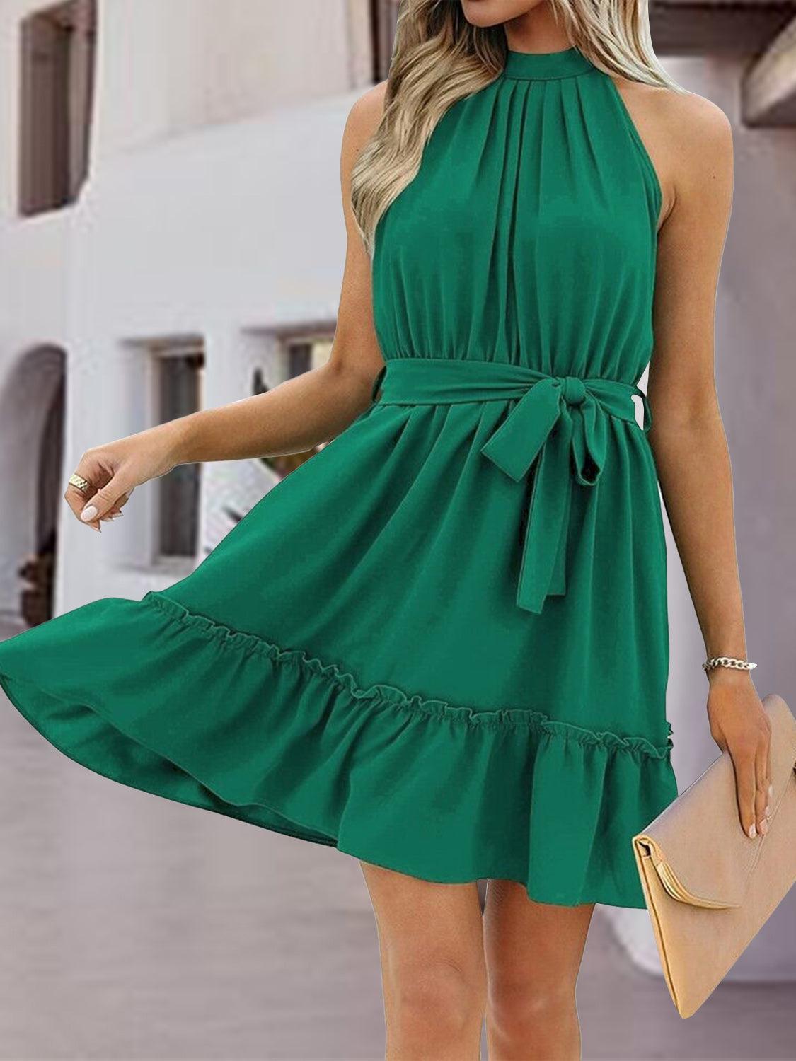 a woman wearing a green dress with a bow at the waist