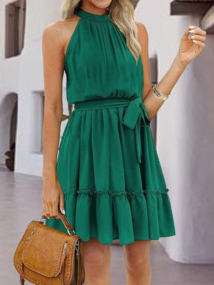 a woman in a green dress holding a brown purse