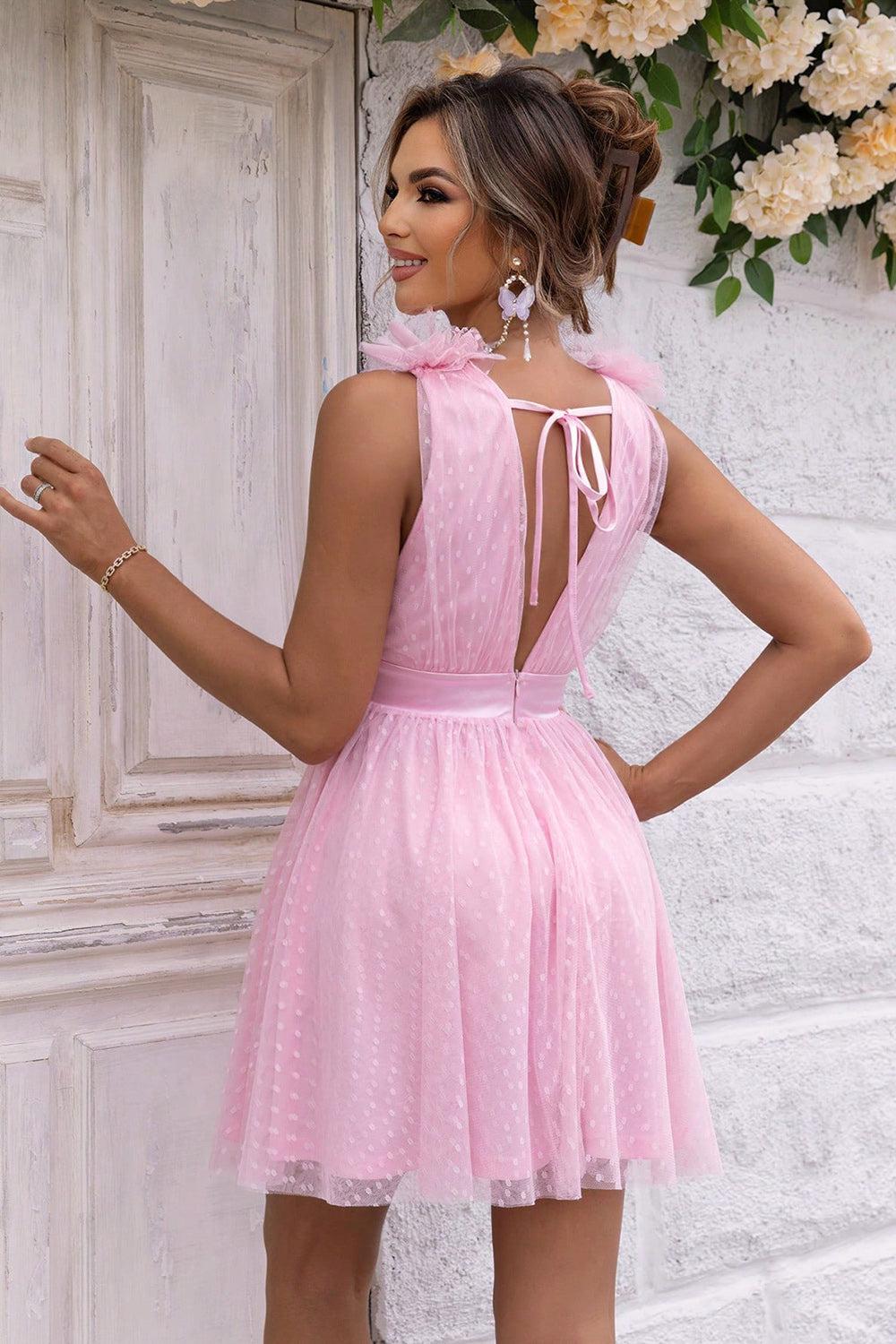 a woman in a short pink dress standing in front of a door