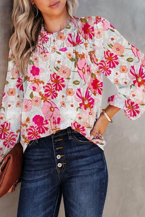 a woman wearing a floral blouse and jeans