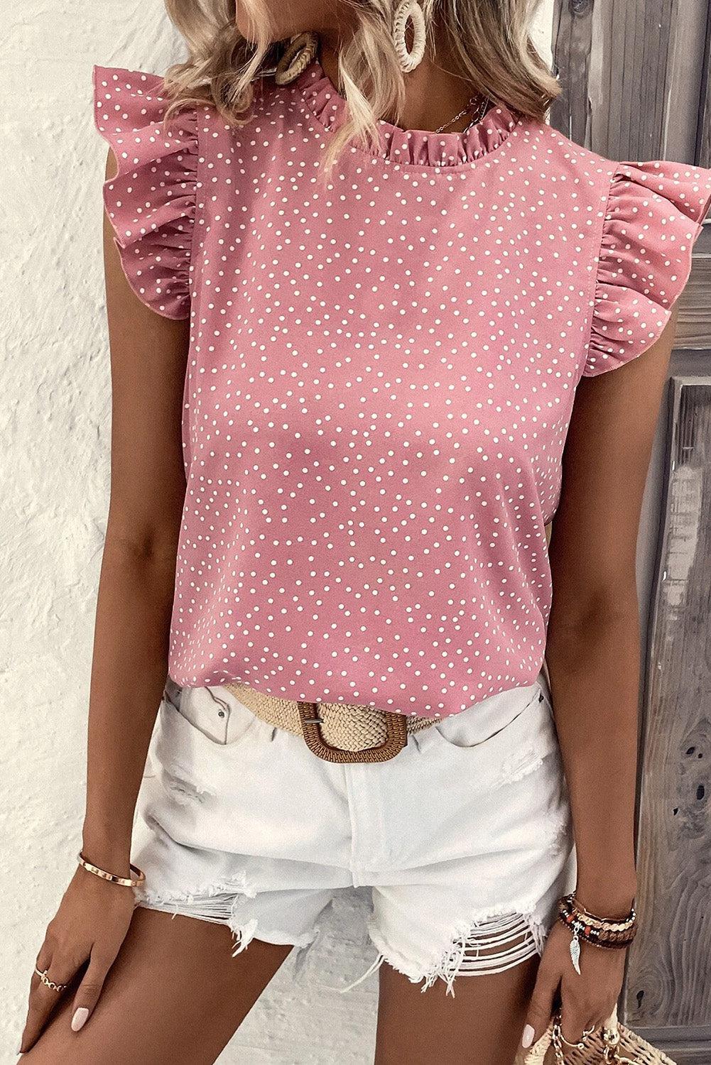 a woman wearing a pink top with white polka dots