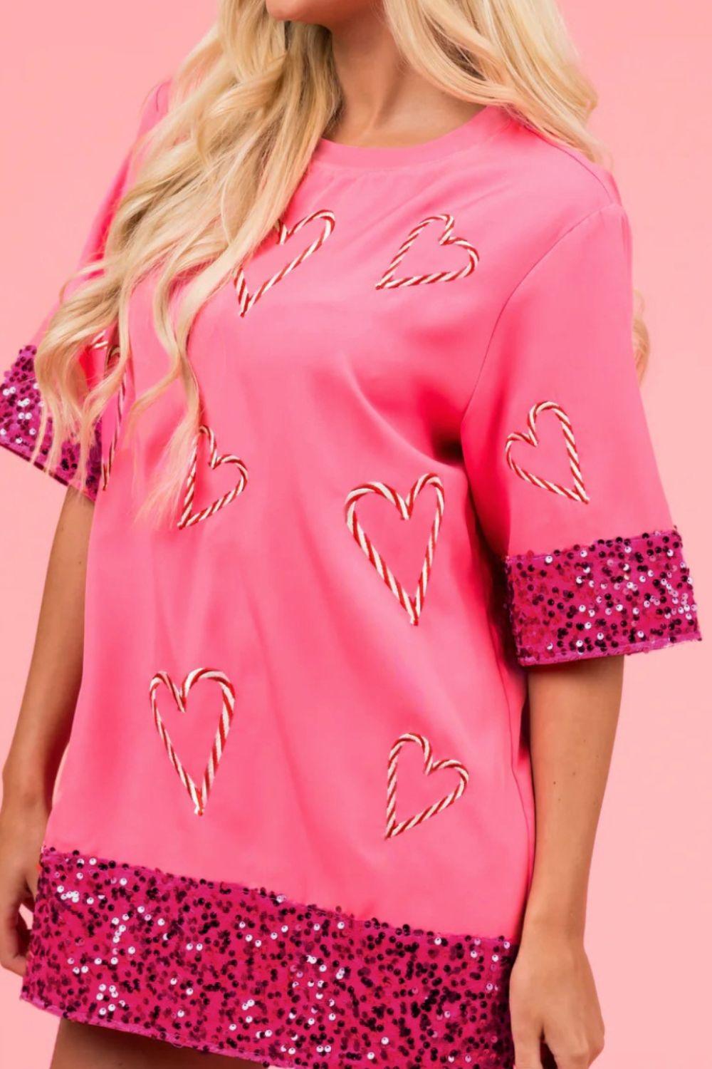 a woman wearing a pink top with hearts on it