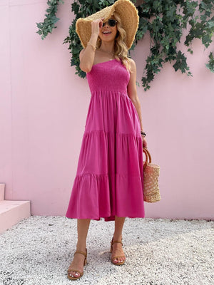 a woman wearing a pink dress and a straw hat