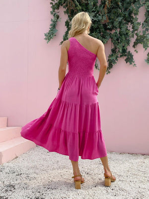 a woman standing in front of a pink wall