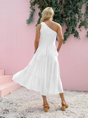 a woman in a white dress standing in front of a pink wall