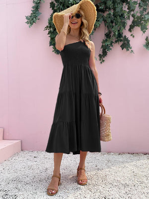 a woman wearing a black dress and a straw hat