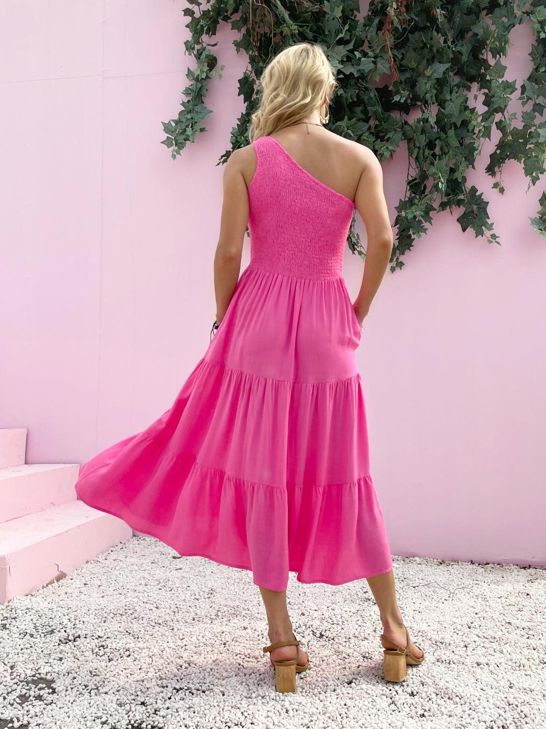 a woman standing in front of a pink wall