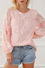 a woman wearing a pink blouse and denim shorts