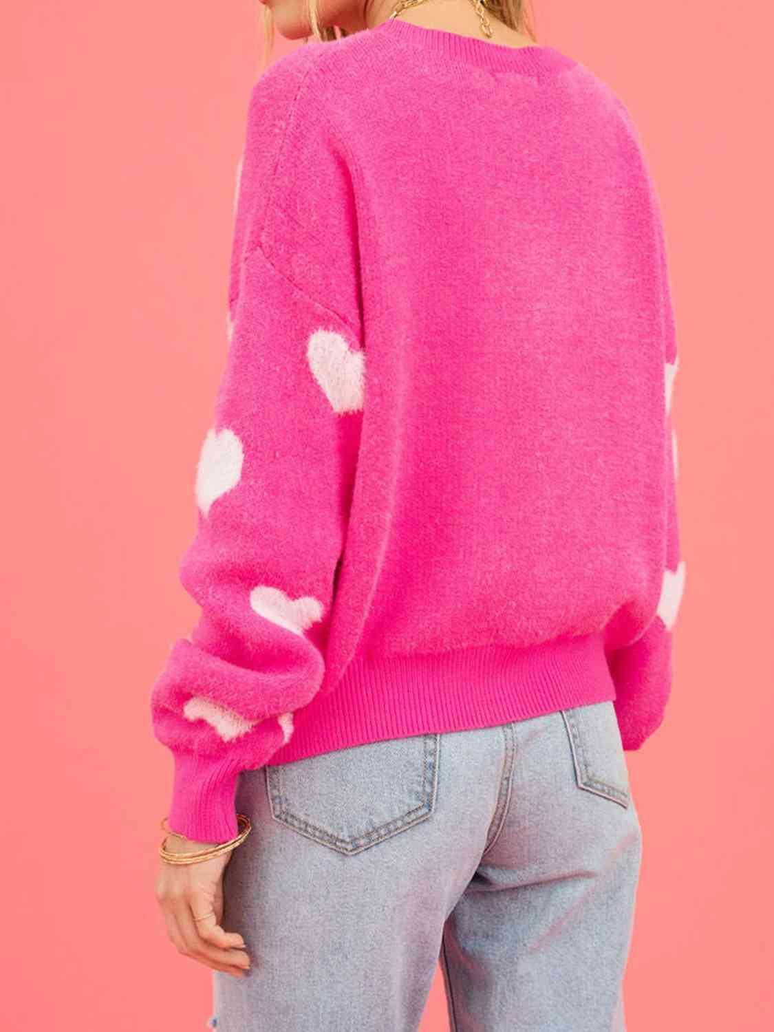 a woman wearing a pink sweater with white polka dots