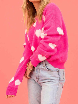 a woman wearing a pink sweater with white hearts on it