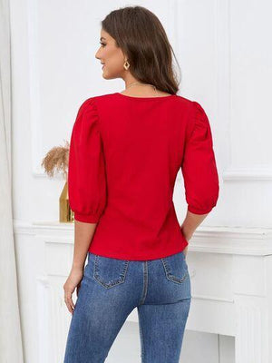 a woman wearing a red top and jeans