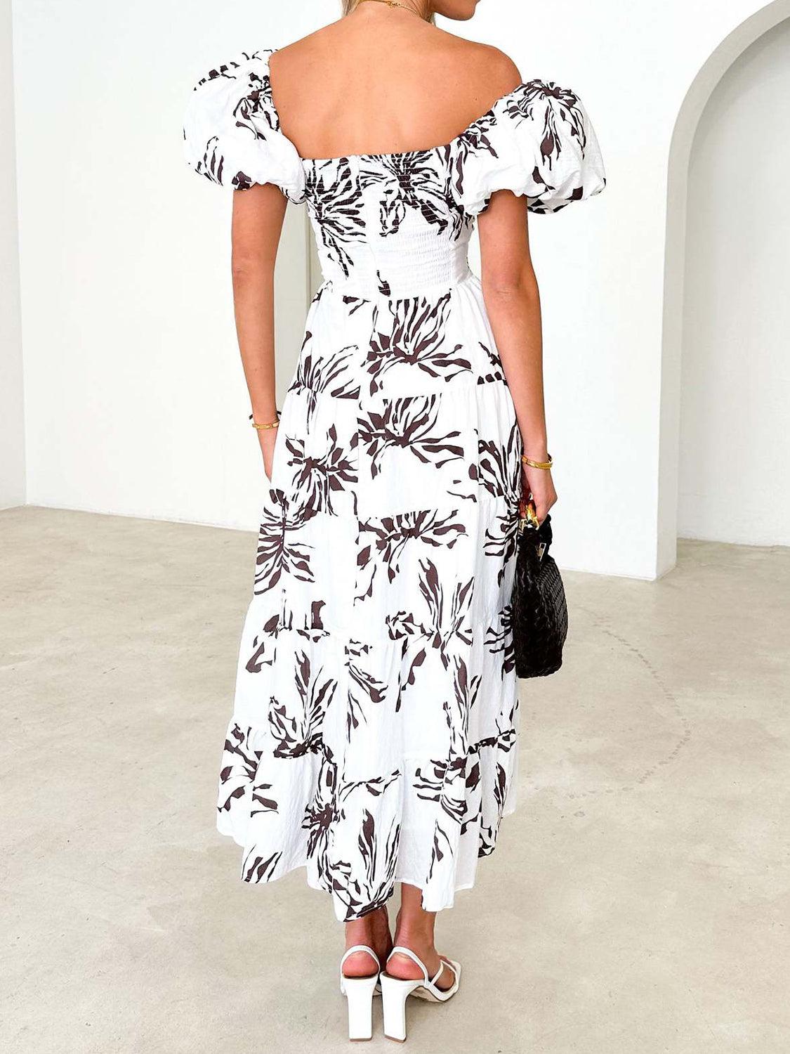 a woman in a white and black floral print dress