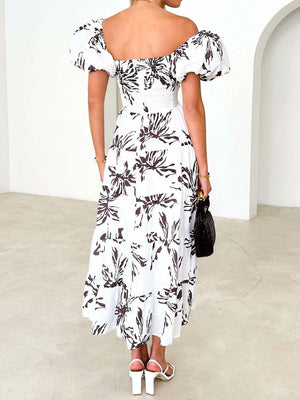 a woman in a white and black floral print dress