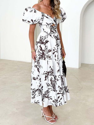 a woman wearing a white and black floral print dress