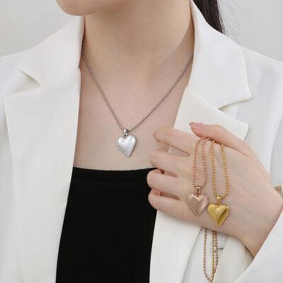 a woman wearing a white jacket holding two heart shaped necklaces