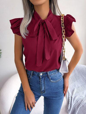 a woman with grey hair wearing a red blouse and jeans