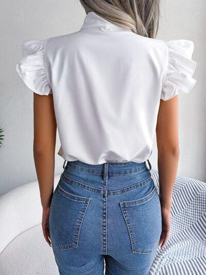 a woman wearing a white blouse and jeans