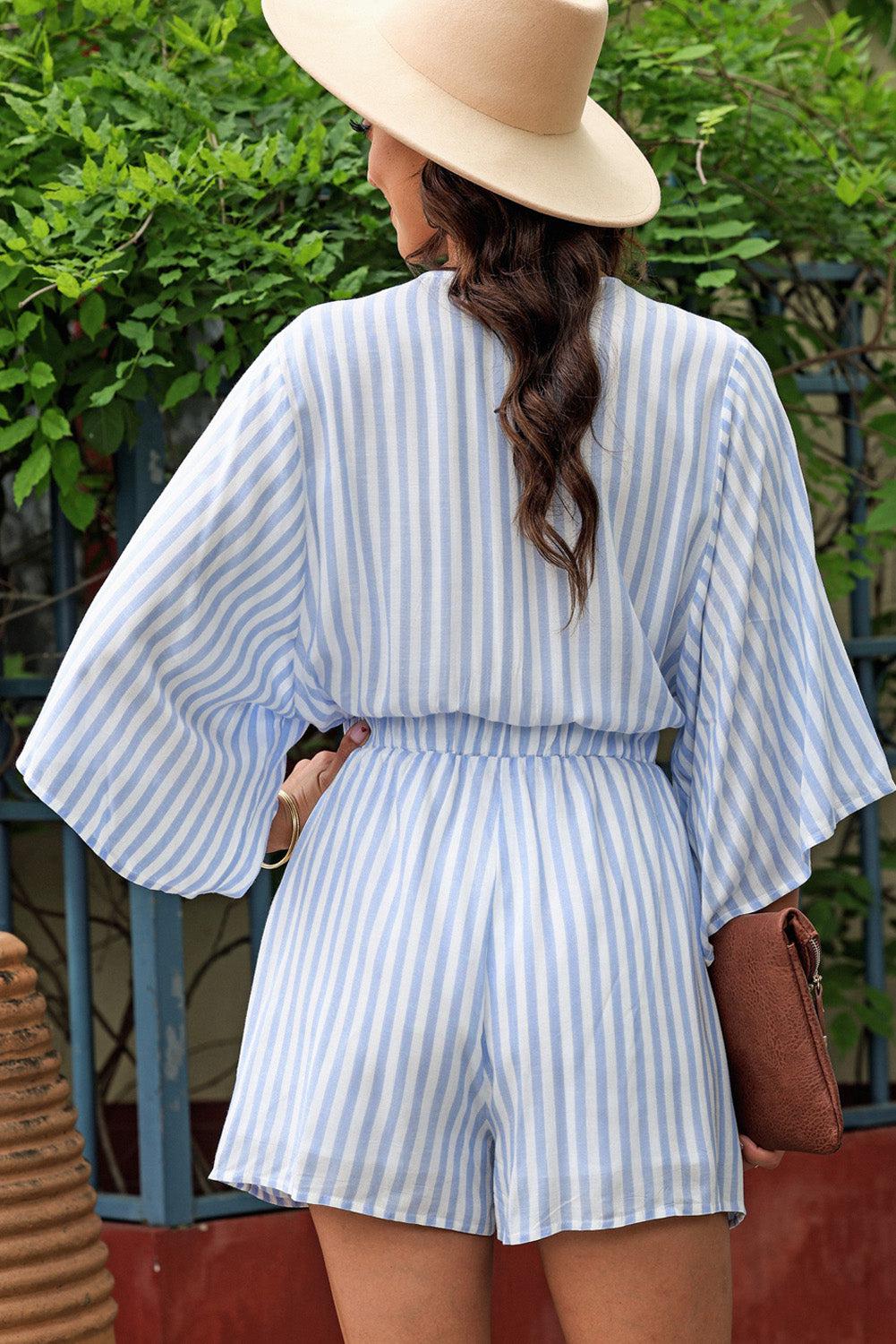 a woman in a blue and white striped romper and hat