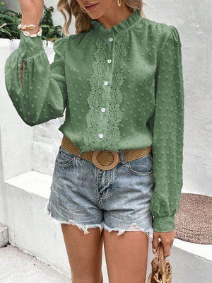 a woman wearing a green blouse and denim shorts