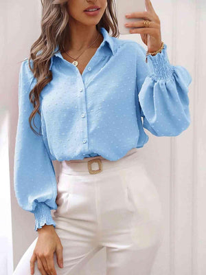 a woman wearing a blue blouse and white pants