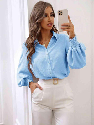 a woman taking a selfie in a blue shirt and white pants