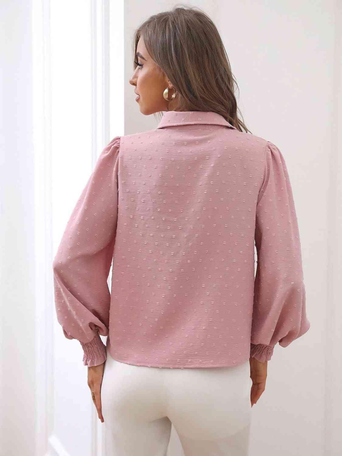 a woman wearing a pink blouse and white pants