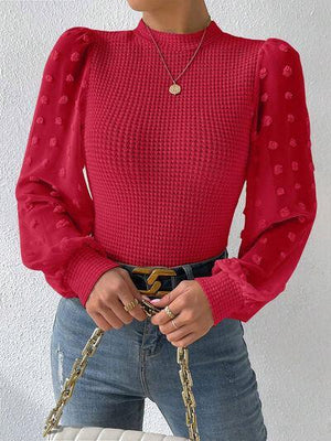 a woman in a red top holding a white purse