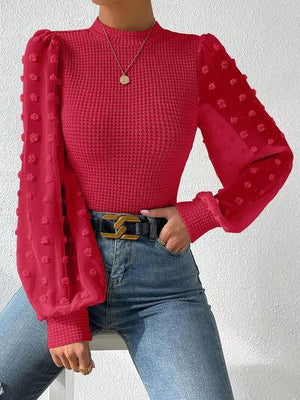 a woman sitting on a chair wearing a red top