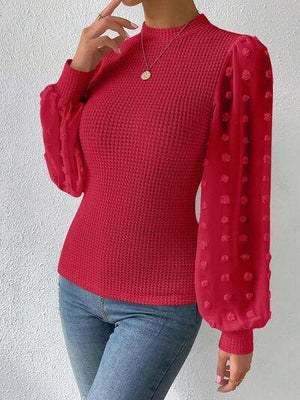 a woman wearing a red sweater and jeans