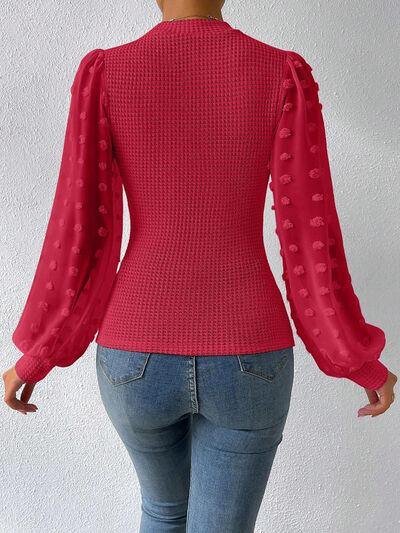 a woman wearing a red sweater and jeans