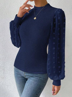 a woman in a blue sweater smoking a cigarette