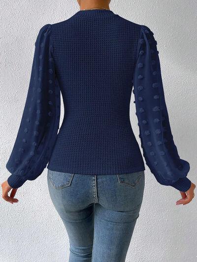 the back of a woman wearing a blue sweater