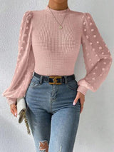 a woman wearing ripped jeans and a pink top