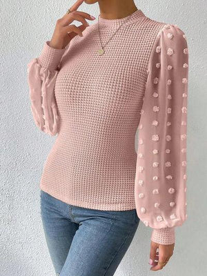 a woman wearing a pink sweater and jeans