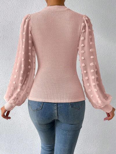 a woman wearing a pink sweater and jeans