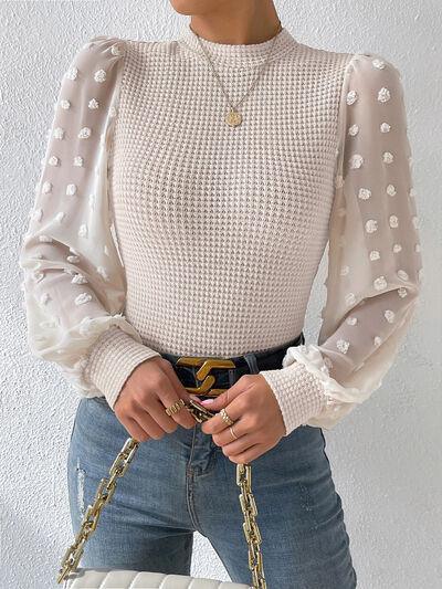 a woman wearing a white top and jeans holding a white purse